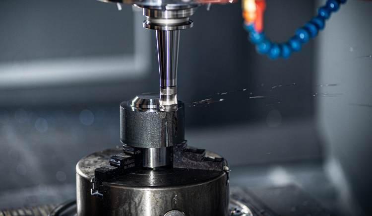 Automated CNC milling machine cutting material on a worktable.