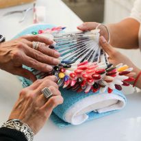 Nail Technician showing nail color to a client.