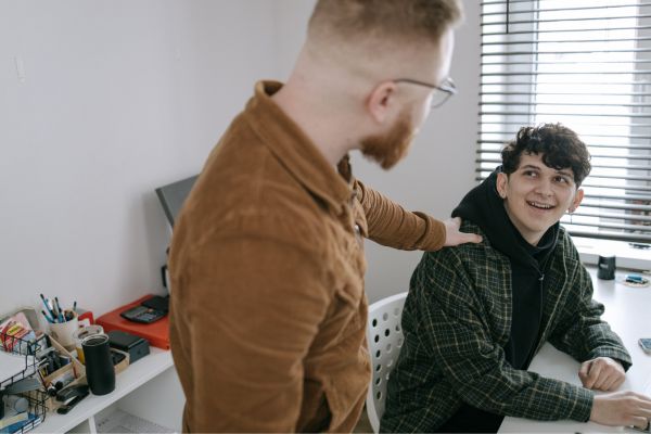 Two persons talking and showing support for each other.