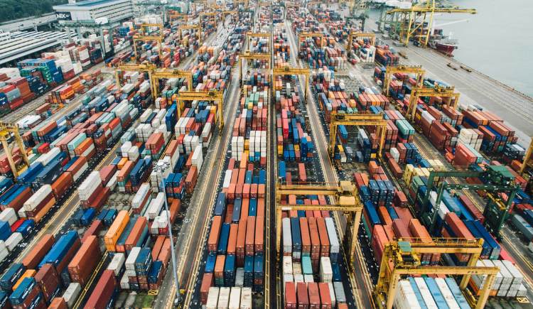 Aerial view of a busy shipping port with rows of colorful cargo containers organized in stacks.