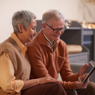 An older couple viewing a tablet together.