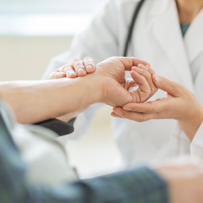 A caregiver checking the pulse of a patient.