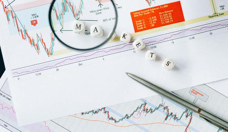 A close-up view of financial charts and graphs spread across a desk